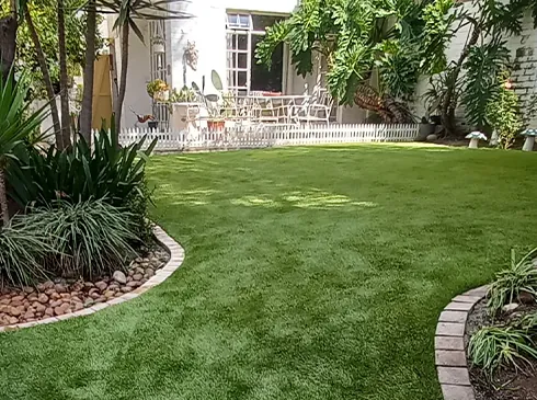 Soft-looking artificial grass in a shaded family garden